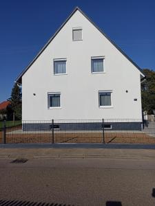 ein weißes Gebäude mit Fenstern auf der Straßenseite in der Unterkunft EBS Paradies in Rheinhausen