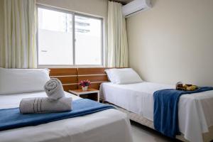 um quarto de hotel com duas camas e uma janela em CNI53 - 2 Dorm, Garagem, Climatizado, Wi-Fi em Balneário Camboriú