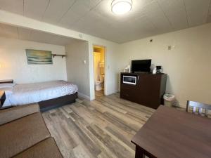 a hotel room with a bed and a television at Holiday Motel in Westport +4 photos