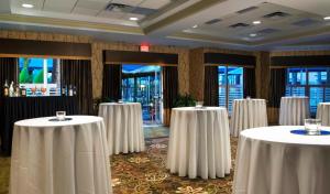 a set of white tables in a room with windows at Holiday Inn Resort Orlando - Lake Buena Vista, an IHG Hotel in Orlando