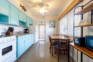 a kitchen with blue cabinets and a table with a dining room at The Desoto - Oceanview Inn in Hollywood