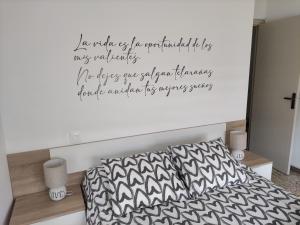 a bedroom with a bed with a quote on the wall at Casa El Callejo de La Fregeneda in La Fregeneda