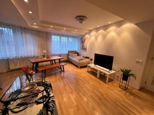 uma sala de estar com um sofá, uma mesa e uma televisão em Iren Apartment Bratislava em Bratislava