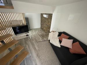 a living room with a black couch and a television at Casinha da fonte in Arcos de Valdevez