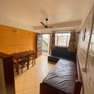 uma sala de jantar com uma mesa e um sofá num quarto em Chales Virena em Ubatuba