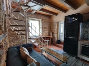 ein Wohnzimmer mit einer Treppe und einer Steinmauer in der Unterkunft MASTIXI Colors in Chios