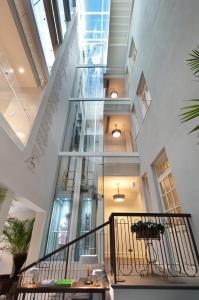 a large glass staircase in a building with plants at The Norman Tel Aviv in Tel Aviv