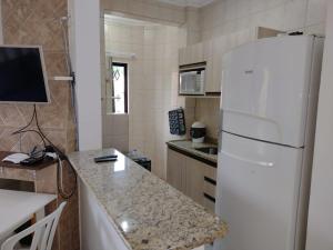 uma cozinha com um frigorífico branco e um balcão em Pousada Vale Del Sol em Bombinhas