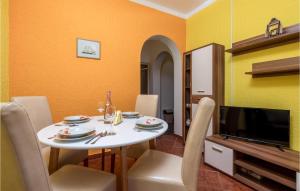 comedor con mesa blanca y TV en Lovely Apartment In Lukovo Sugarje With Kitchen, en Barić Draga