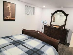 a bedroom with a bed and a dresser and a mirror at QUIET Appartment near Montreal CITQ 3O9764 in Longueuil