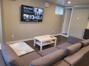 uma sala de estar com um sofá e uma televisão em QUIET Appartment near Montreal CITQ 3O9764 em Longueuil