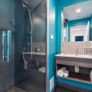 uma casa de banho com um chuveiro e um lavatório. em Roomie Apartment Hotel em Auckland