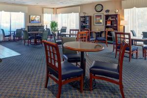 a waiting room with tables and chairs at Howard Johnson by Wyndham Amherst Hadley in Amherst