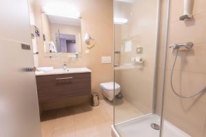 a bathroom with a shower and a sink and a toilet at Das Reinisch Business Hotel in Schwechat