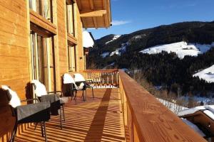 a balcony with chairs and a view of a mountain at Chalet Ausblicklodge in Mühlbach am Hochkönig