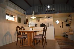 kuchnia i jadalnia ze stołem i krzesłami w obiekcie Nice holiday home in Hokensas nature reserve w mieście Tidaholm