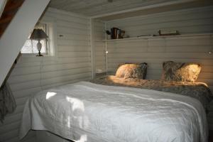 1 dormitorio con 1 cama con sábanas blancas y ventana en Nice holiday home in Hokensas nature reserve en Tidaholm