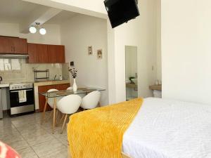a bedroom with a bed and a table and a kitchen at Detailed and Modern Apartment D in Guatemala