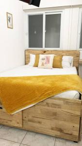 1 dormitorio con 1 cama grande con marco de madera en Detailed and Modern Apartment D, en Guatemala