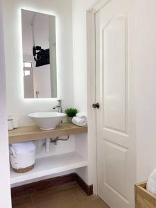 a white bathroom with a sink and a mirror at Detailed and Modern Apartment D in Guatemala