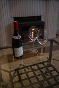 a bottle of wine and two wine glasses on a table at *OKALEE* in Dinan