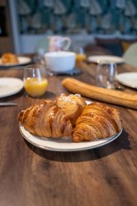 a table with a plate of croissants and pastries on it at *OKALEE* in Dinan