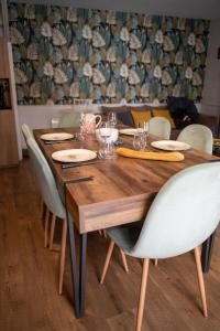 a wooden table with chairs and plates and glasses at *OKALEE* in Dinan