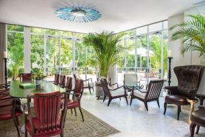 a dining room with a table and chairs and windows at The Norman Tel Aviv in Tel Aviv