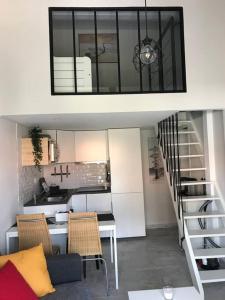 een woonkamer met een trap en een keuken bij Villa patio classée proche océan in Capbreton