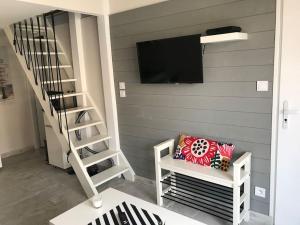 een kamer met een trap met een tv aan de muur bij Villa patio classée proche océan in Capbreton