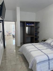 een slaapkamer met een bed en een tv. bij HB Alebrijes SC in Lachiraguigú
