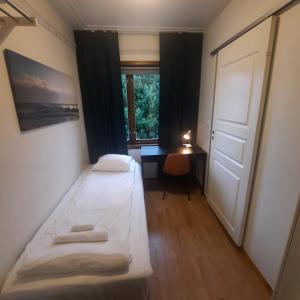 um pequeno quarto com 2 camas e uma janela em Guesthouse- Møllegata 39 em Stavanger