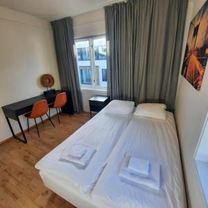 um quarto com uma cama, uma secretária e uma janela em Guesthouse- Møllegata 39 em Stavanger