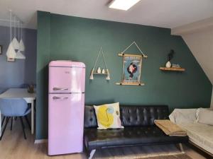 a pink refrigerator in a living room with a couch at Beautiful Cozy apartments close to lakes and nature parks in Schwandorf in Bayern