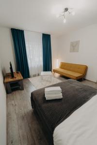 Habitación de hotel con cama y sofá en Apartamentul Galben, en Vatra Dornei