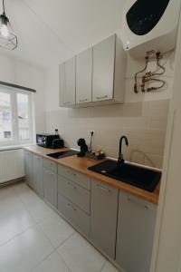 a kitchen with white cabinets and a sink at Apartamentul Galben in Vatra Dornei