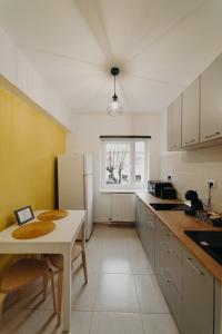 a kitchen with a table and a white refrigerator at Apartamentul Galben in Vatra Dornei