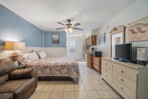 a bedroom with a bed and a couch and a tv at Sahara Motel in North Wildwood