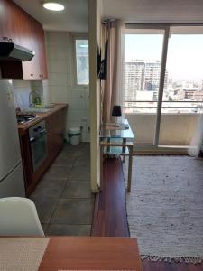 a kitchen with a counter and a table and a window at DEPARTAMENTOS SANTIAGO CENTRO #3 in Santiago