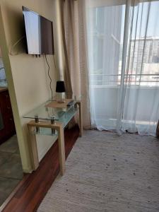 a living room with a glass table and a television at DEPARTAMENTOS SANTIAGO CENTRO #3 in Santiago