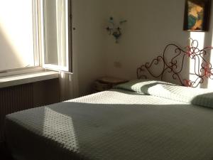 een slaapkamer met een bed met een wit dekbed en een raam bij Villa Giulia in Grado
