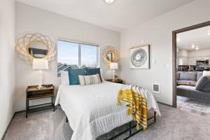 a white bedroom with a bed and a mirror at Brand New 2 Bd 2 Bth Near DT and Perry District in Spokane