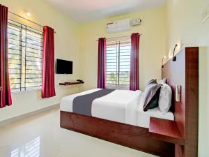 a bedroom with a large bed with red curtains at BLUEWAY RESIDENCY BUSINESS BOUTIQUE HOTEL in Trivandrum