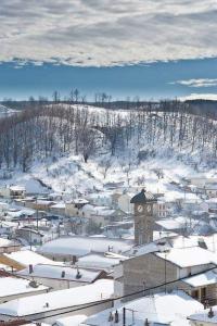 miasto pokryte śniegiem z wieżą zegarową w obiekcie Villa Ria 