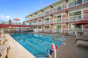 a pool at a hotel with tables and chairs at Sahara Motel in North Wildwood