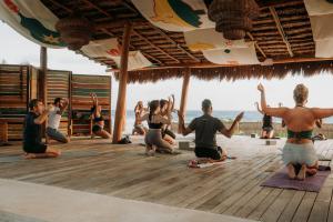 a group of people doing yoga on the beach at Selina Poc Na Isla Mujeres in Isla Mujeres