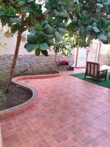 a brick patio with a tree and a bench at Villa Marmara in Al Madinah