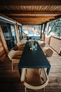 einen schwarzen Tisch und Stühle auf einer Holzterrasse in der Unterkunft SEA HOUSE shade, pool & jacuzzi - PRIVILEGE POINT camping villas in Selce
