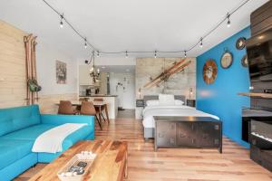 a living room with a blue couch and a bed at Initial / Loft de la montagne / MSA in Saint-Férréol-les-Neiges
