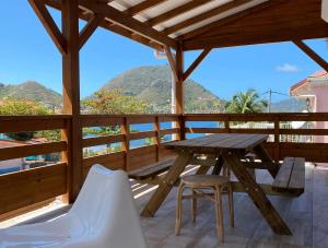 a table and chairs on the deck of a house at Haut de villa Taalia in Terre-de-Haut